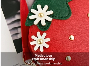 Close-up of red strawberry bag featuring lychee grain leather and white floral details