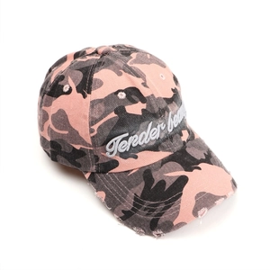 Detail of Tender Beauty script embroidery on distressed camouflage baseball cap brim