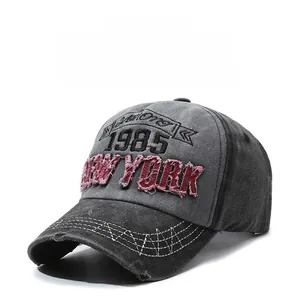 Detail of distressed grey washed baseball cap with 1985 New York patch embroidery
