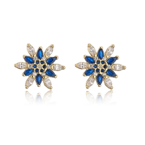 Dettaglio macro di orecchini a fiore placcati oro 18K con zirconi blu e trasparenti