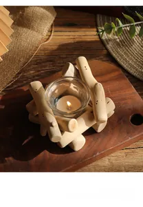 Detalle de portavelas rústico de madera y vidrio con vela encendida en bandeja de madera