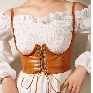 Vue détaillée du corset en cuir marron caramel avec laçage frontal et boucles argentées