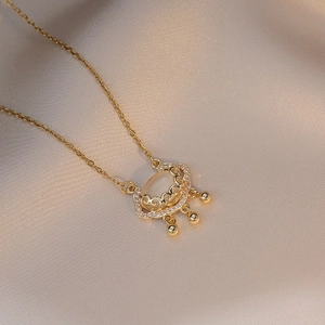 Detail shot of golden Ping'an Lock necklace with cat's eye stone and Ruyi clouds