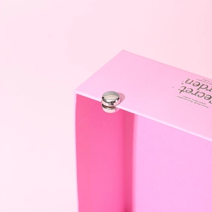 Close-up of a silver magnetic scarf buckle inside a pink Secret Garden gift box