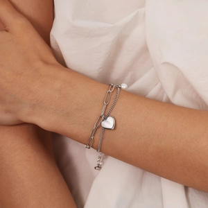 Elegant double-layered silver chain bracelet with a heart pendant and pearl on model