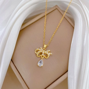 Detail of gold butterfly necklace with crystal teardrop on silk jewelry box display