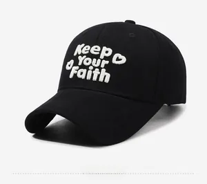 Detail der weißen 3D-Stickerei Keep YOUR Faith auf einer schwarzen Baumwoll-Baseballkappe