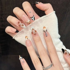 Almond-shaped press-on nails with leopard spots, black French tips and crystal accents
