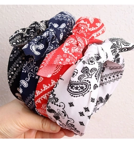 Close-up of four colorful paisley print bow headbands in black, navy, red and white fabric