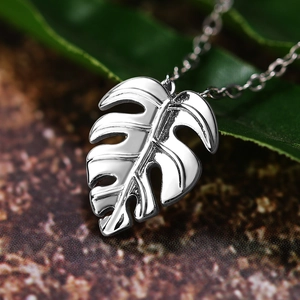 Polished silver monstera leaf pendant necklace on a delicate chain for women