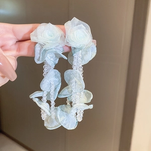 Gedetailleerd beeld van blauwe raffia bloemoorbellen met elegante heldere kralen