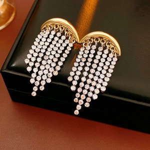 Detail of sparkling rhinestone tassel moon earrings on a black leather jewelry display