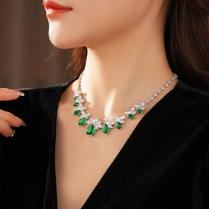 Gros plan d'un ensemble collier avec gouttes d'émeraude et fleurs sur un mannequin