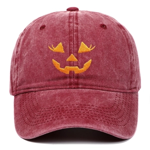 Close-up of Halloween pumpkin embroidery on washed wine red cotton baseball cap