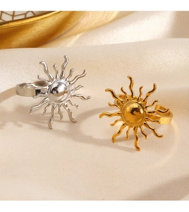 Nahaufnahme goldener und silberner Sonnenringe auf elegantem beigefarbenem Seidenstoff