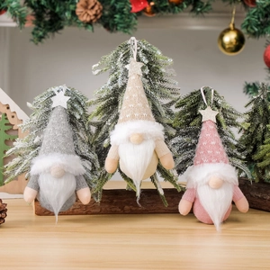 Three plush Christmas gnomes with knitted hats and white fur beards for holiday decoration
