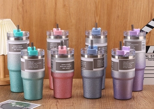 Glitter insulated stainless steel cups in 20oz and 30oz sizes on a wooden table