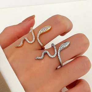 Detailed close-up of adjustable snake rings in gold and silver finish with crystal pavé