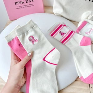Close-up of pink striped cotton socks featuring cute bear embroidery and ribbed cuffs