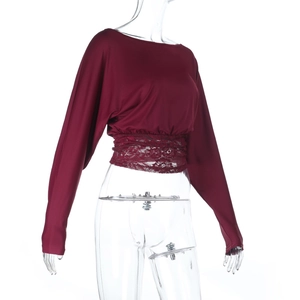 Detail of burgundy long sleeve top featuring lace patchwork waist and cropped cut