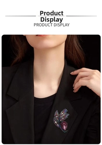 Detailed view of a purple teardrop gem brooch on a black blazer lapel with intricate weaving