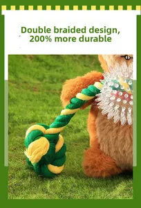 Detail of durable double-braided cotton pet rope toy with rubber ball on green grass