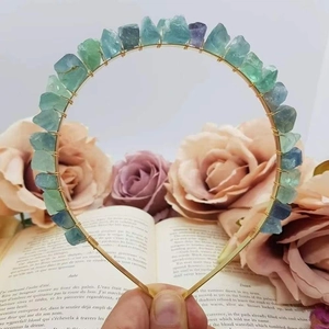 Detail of handmade crystal headband with green and purple natural raw stones on golden wire