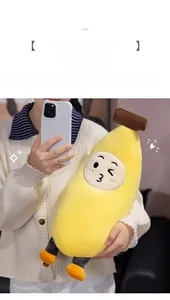 Close-up of cute banana plush pillow with embroidered expression held by a model