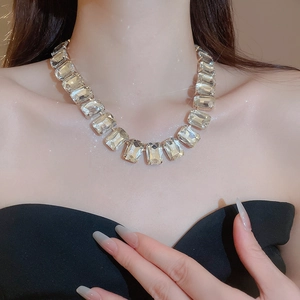 Close-up of elegant square-cut crystal necklace on model featuring high-gloss tassels