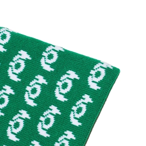 Close-up of emerald green jacquard knit fabric with white repeating letter patterns