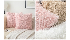 Close-up of soft plush pillow covers in pink and white on a modern cream sofa