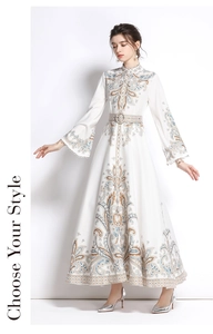 Dettaglio delle maniche a campana e motivo paisley blu su un abito lungo bianco con scollo a V