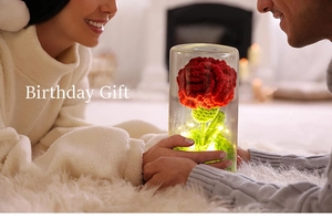 Handmade knitted red flower night light in a glass dome with warm LED string lights