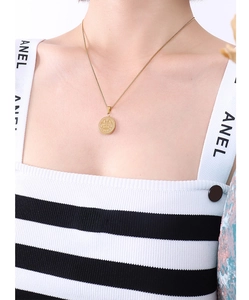 Golden titanium steel justice scale pendant necklace displayed on a female model