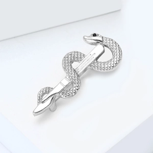 Macro shot of silver snake caduceus brooch with textured scales and black gemstone eye