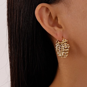 Gros plan de boucles d'oreilles créoles dorées géométriques en U avec strass brillants