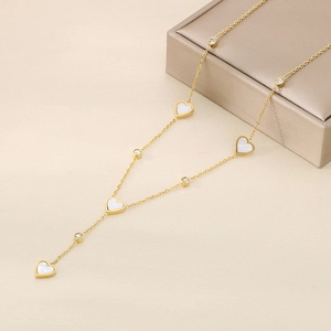 Detail of gold heart necklace with white pendants and rhinestones on jewelry box
