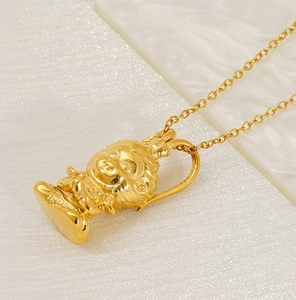 Detail of 18K gold-plated stainless steel necklace with cartoon monk pendant and matte finish