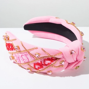 Dettaglio fascia rosa con nodo, ricamo XOXO in perline e strass a cuore lucidi