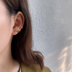 Close-up of minimalist golden double-hoop ear cuff on ear bone for a modern look