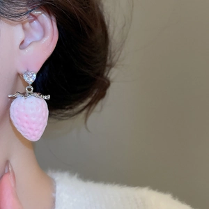 Close-up of pink flocked strawberry earrings with heart-shaped zircon on a model