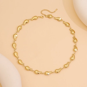 Detailed close-up of golden necklace featuring teardrop pendants and lobster clasp closure