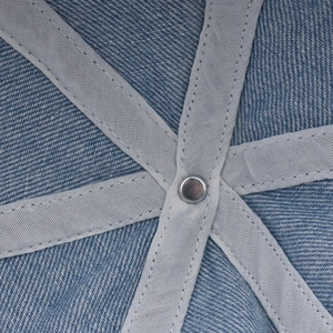 Macro shot of washed denim baseball cap interior stitching and metal rivet detail