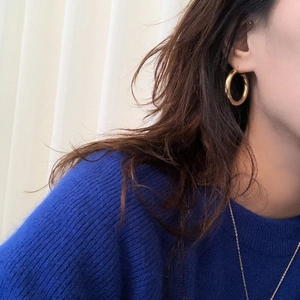 Chic 925 sterling silver hoop earrings with a glossy golden finish on a female model
