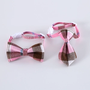 Close-up of pink and brown plaid pet bow tie set with adjustable white plastic buckle strap