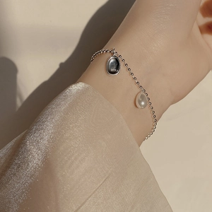 Detailed close-up of S925 sterling silver beaded bracelet with baroque pearl and oval tag