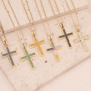Dettaglio di sei collane croce in oro 18K con pietre colorate su base di pietra beige
