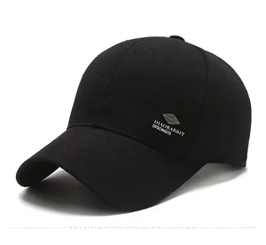Detail of black cotton baseball cap showing side silver metal badge and white printed text