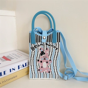 Detail view of blue striped knitted crossbody bag with cute pink bunny pattern and strap
