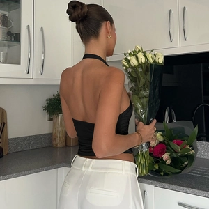 Détail du design dos nu et licou chic sur un haut en tricot noir à coupe ajustée